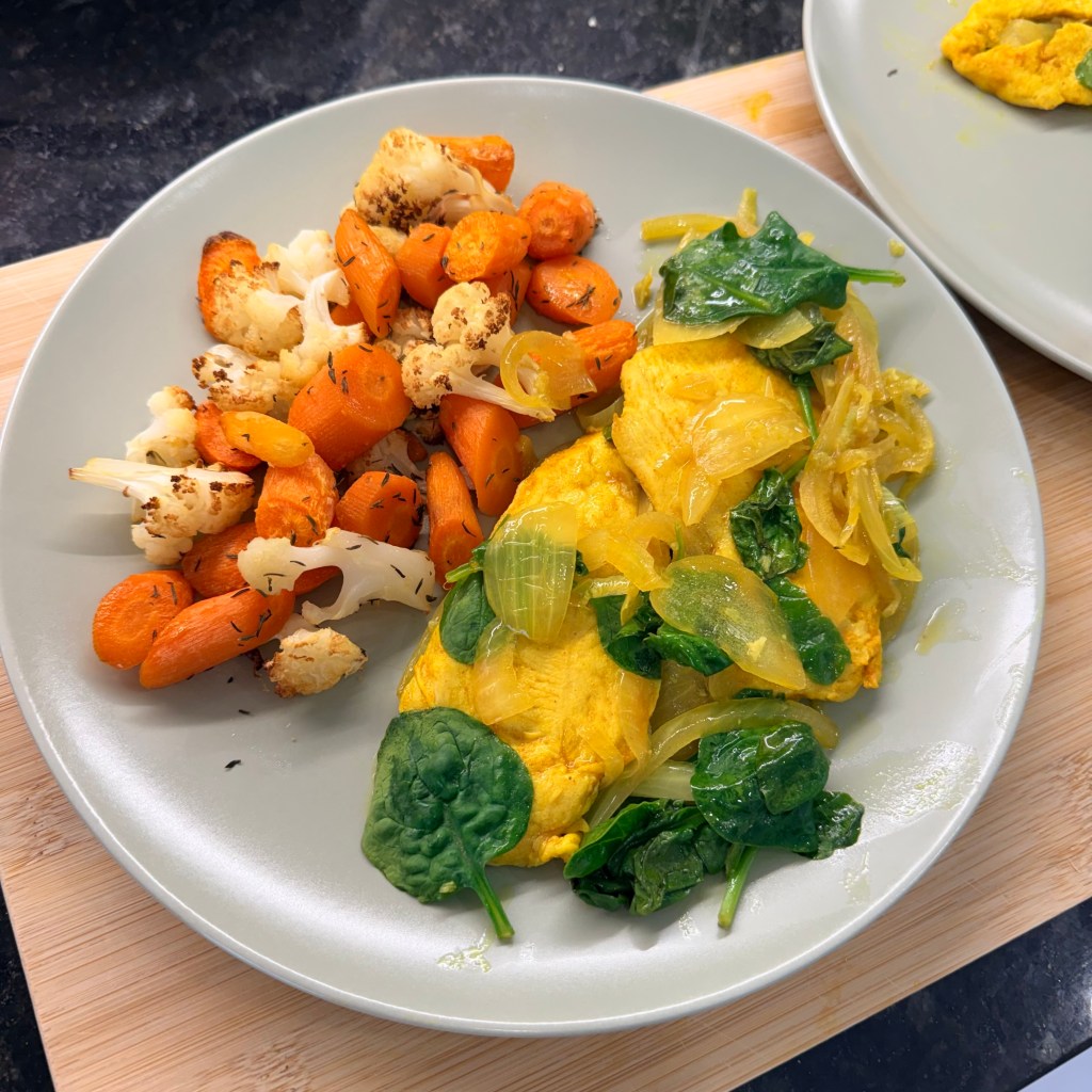 Persian Chicken with spinach and onions, plated with roasted cauliflower and carrots with thyme.