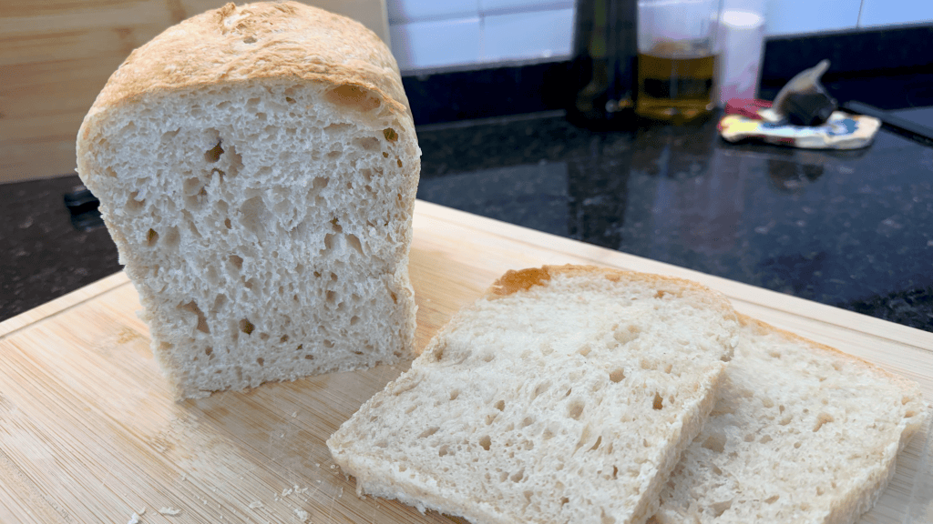 sliced sourdough bread loaf on wood cutting board
